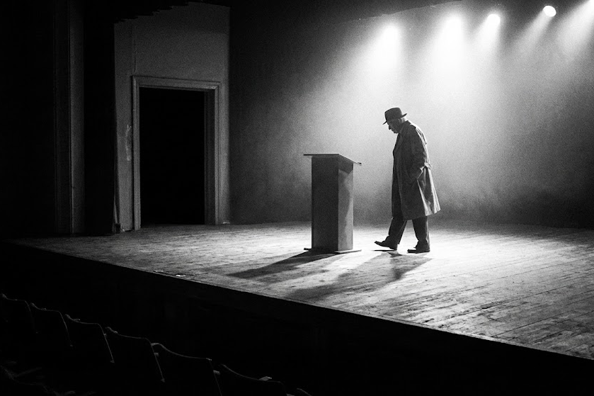 Silhueta de um homem idoso caminhando para fora de um palco, simbolizando a aposentadoria de Philip Yancey do ministério público.